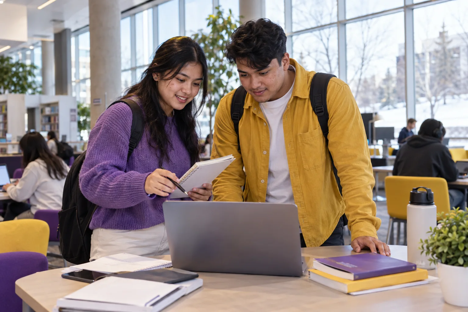 Two Nepali students, one woman and one man comparing Canadian university courses and intake options using a laptop and notebook for Canada study planning