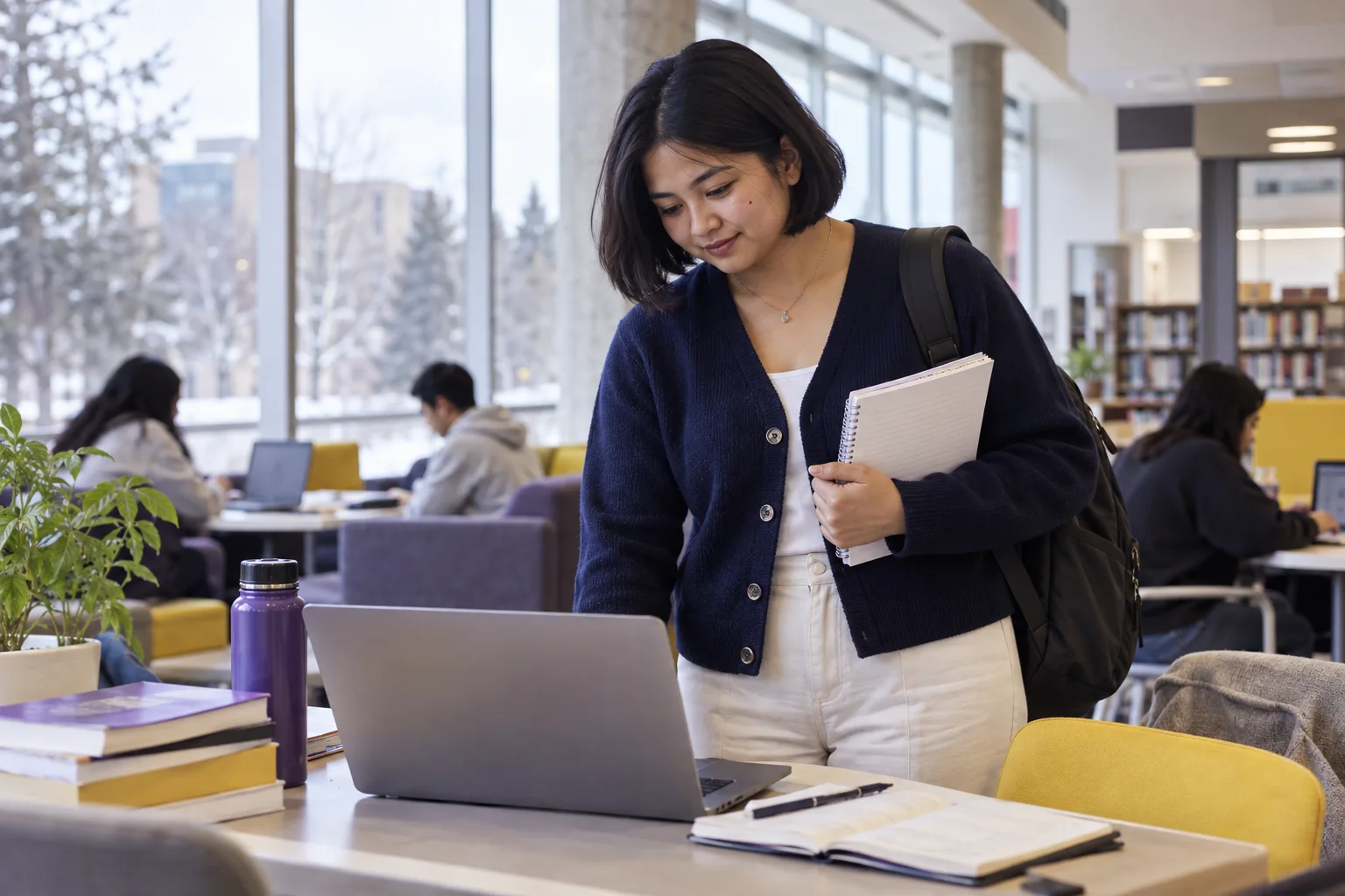 Young Nepali woman with a short bob comparing Canadian university courses and intake options using a laptop and notebook for Canada study planning