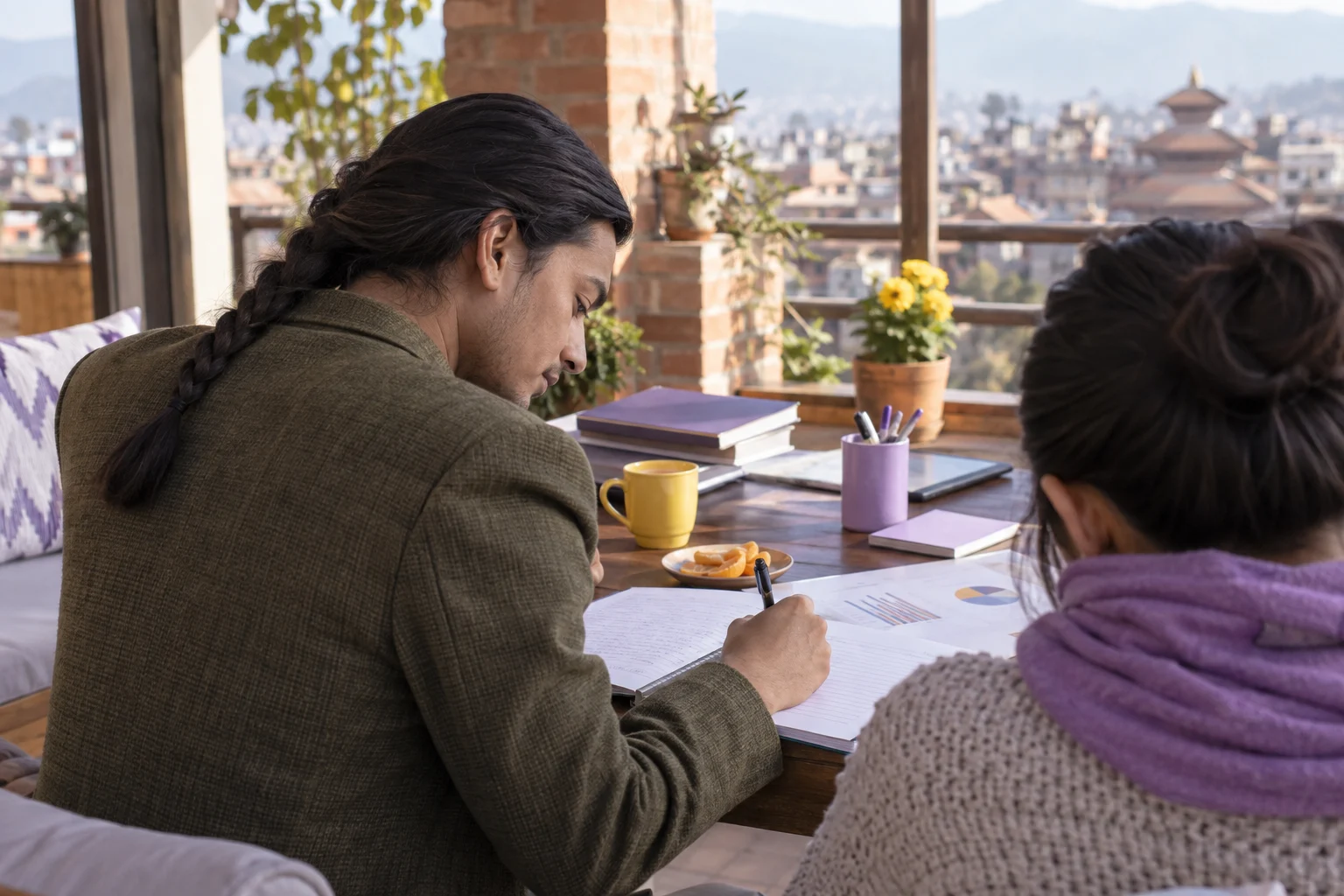 IELTS learner writes a Task 1 overview while studying on a terrace