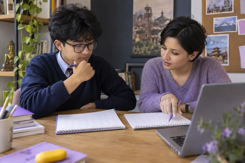 Nepali teenage boy comparing SAT test dates on a calendar with a tutor